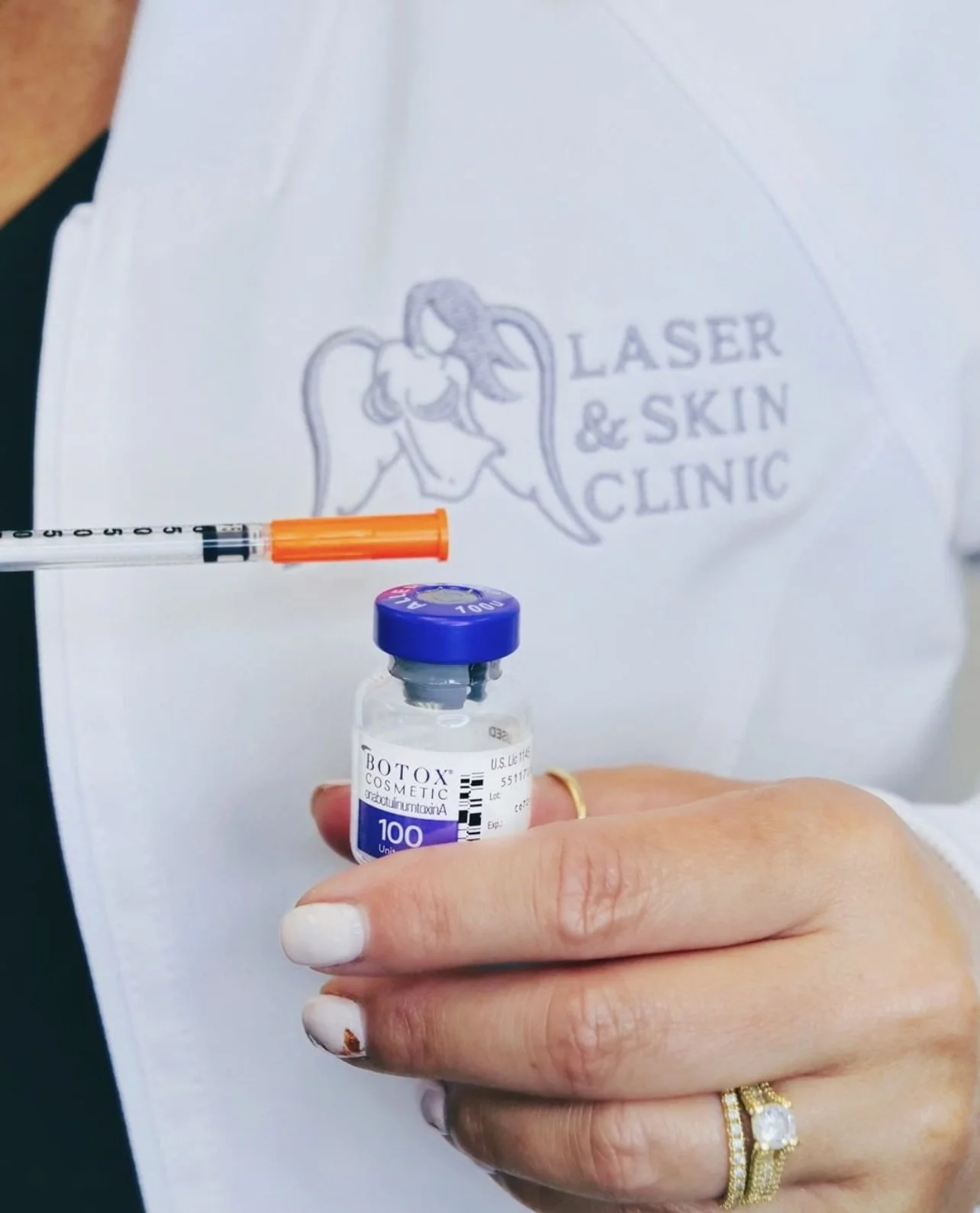 Closeup image of female clinician holidng a bottle of Botox cosmetic serum and a needle alongside it