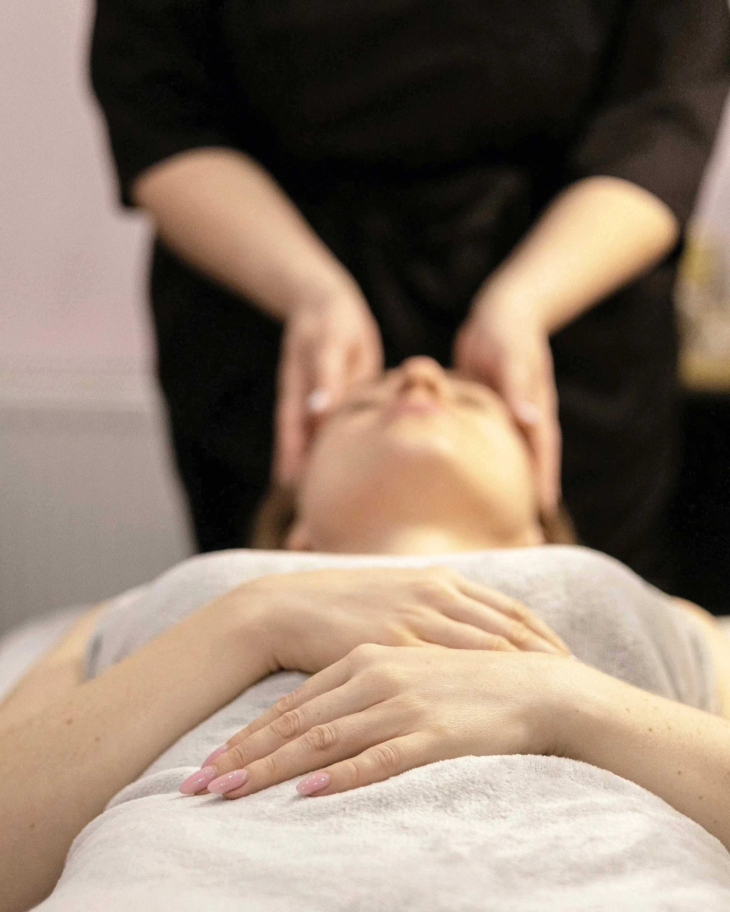 Person receiving a facial massage at spa or wellness center