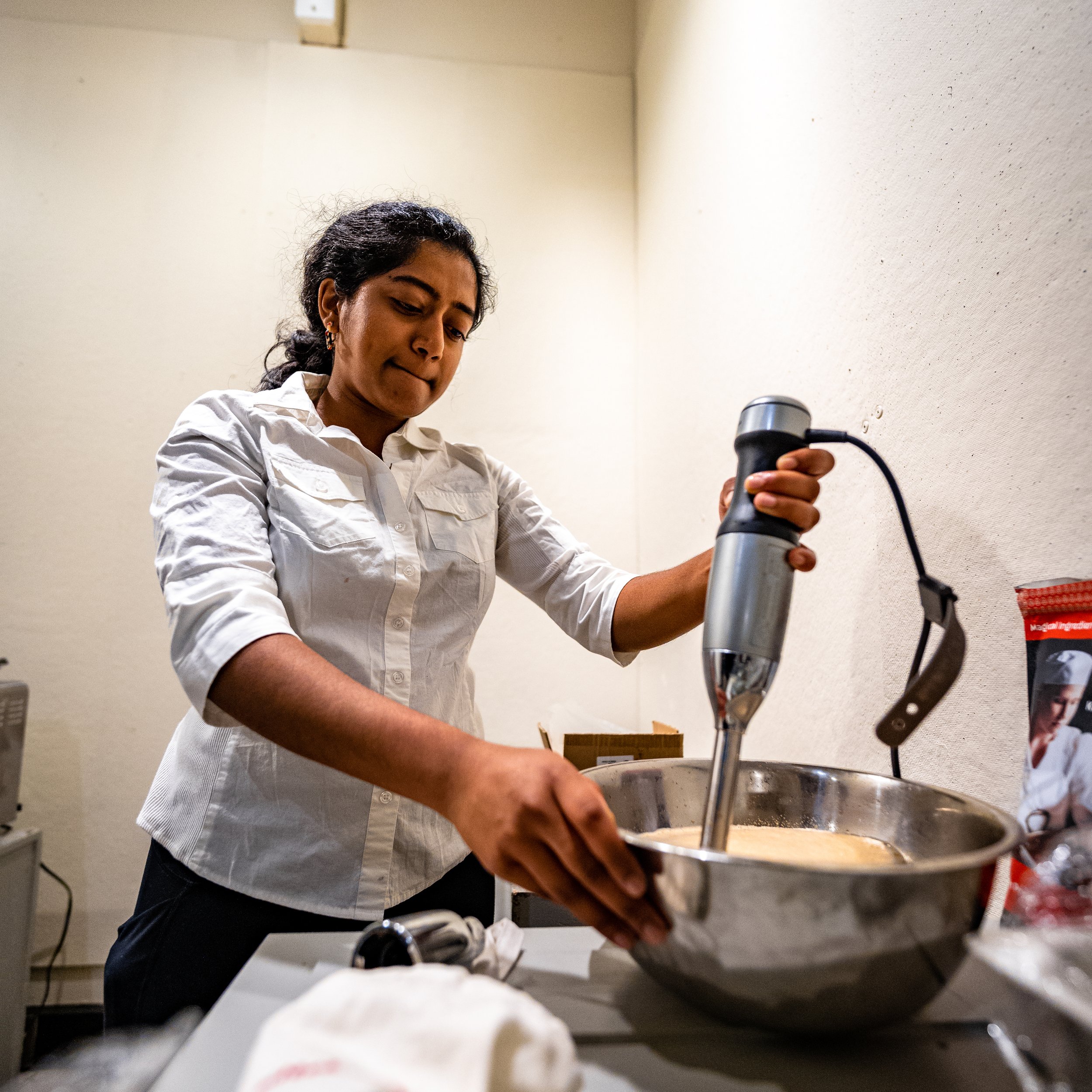 Sangita whipping up culinary foam in the MINCE portable kitchen before serving.