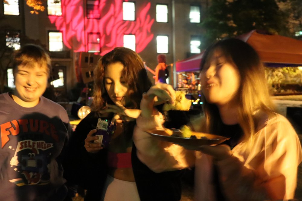 People enjoying MINCE food as band plays in the courtyard