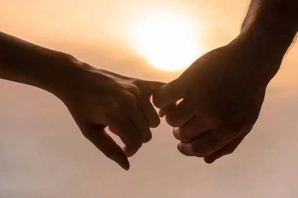 Two people holding hands in a moment of connection and support
