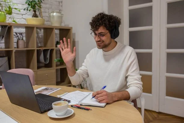Person using a laptop during a virtual therapy session in a calm home environment
