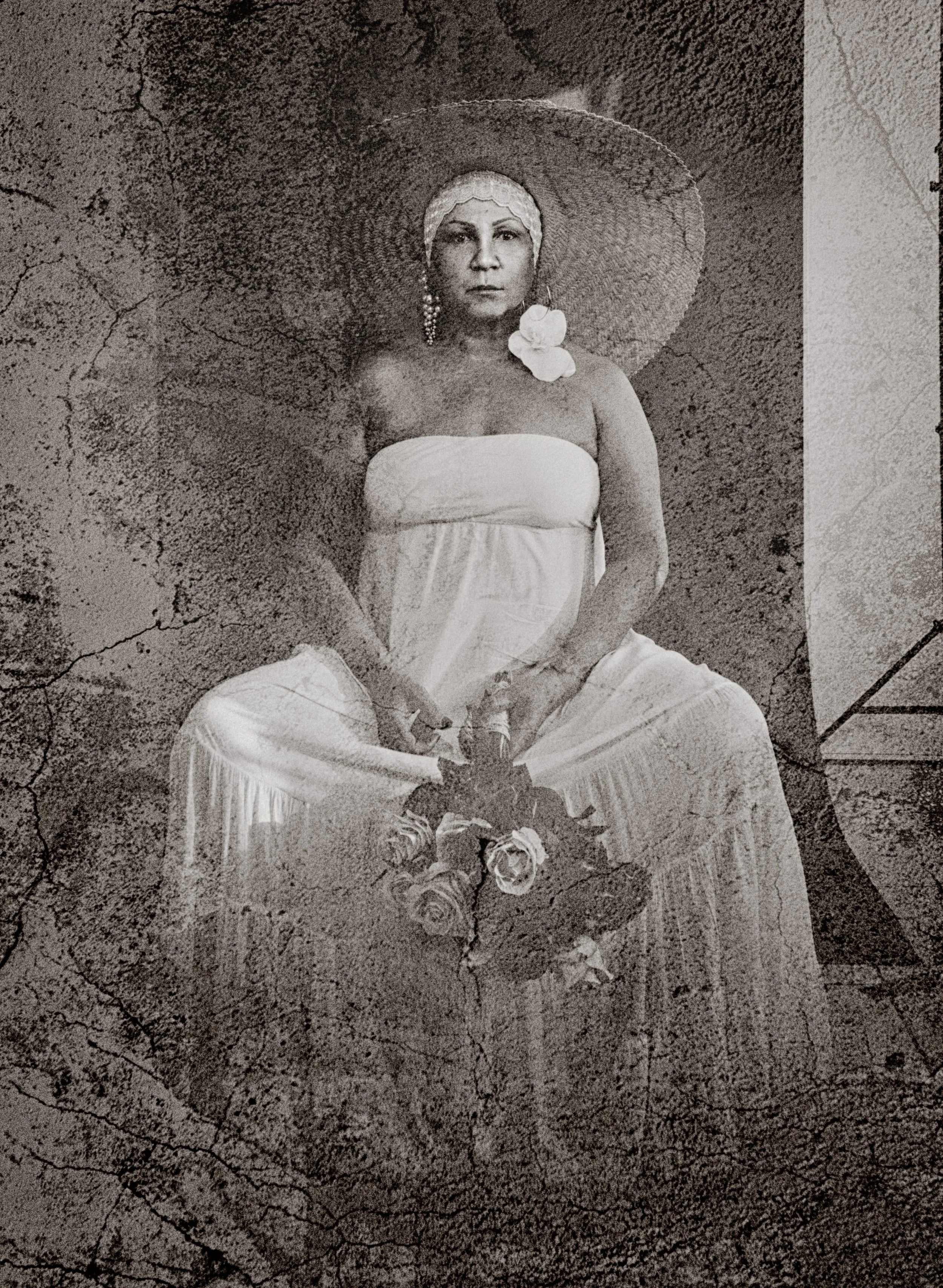 Autoportrait artistique de Vanessa Fennel en robe claire et grand chapeau, dans une composition texturée en noir et blanc.