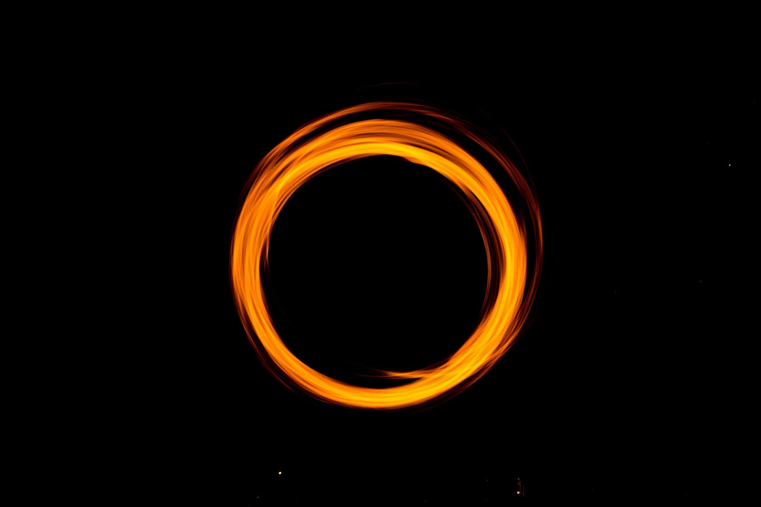 Kreis aus brennender Flammen in dunklem Hintergrund.