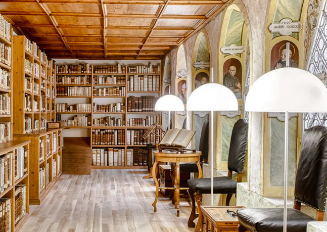 Bibliothek mit Holzwänden, Büchern, Leselampen und Stühlen