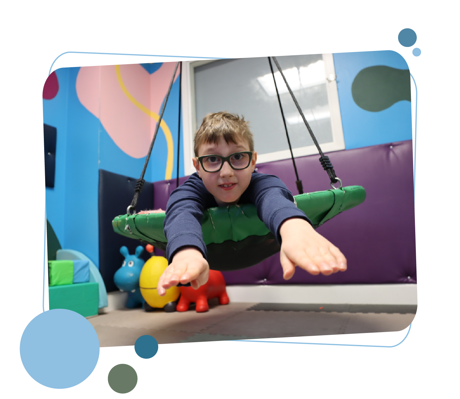 An image of a child using a sensory swing at Quest4Change.