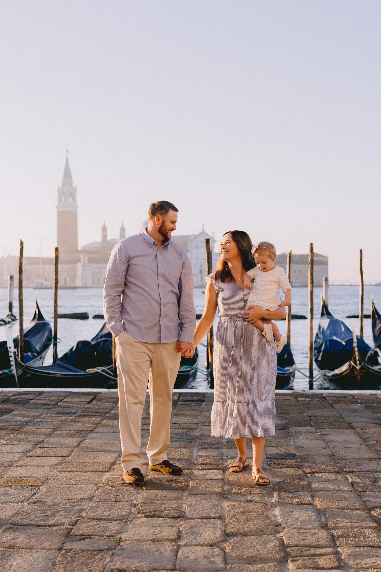Family walking near gondolas at sunrise