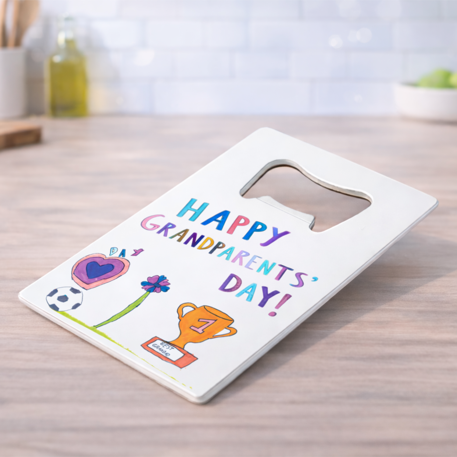 White bottle opener printed with drawings and words saying Happy Grandparents' Day!