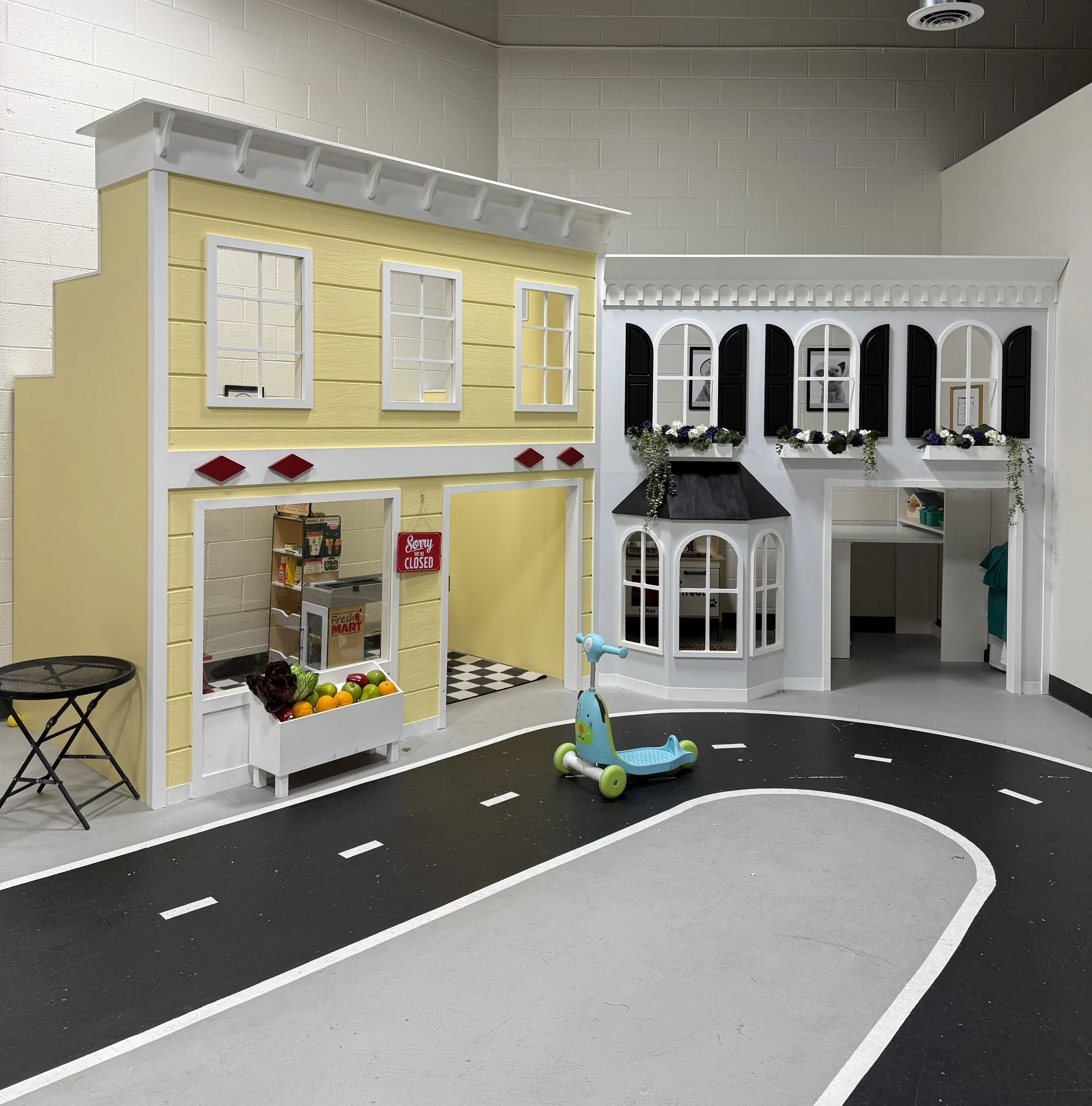Indoor play area for children with autism with a miniature storefront resembling a grocery store.