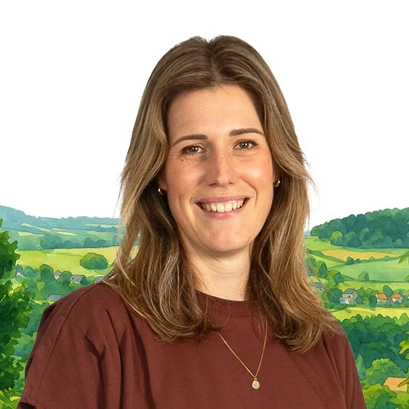 Portret van een glimlachende vrouw met bruin haar, gekleed in een bruin shirt, voor een illustratieve achtergrond van groene heuvels en velden.