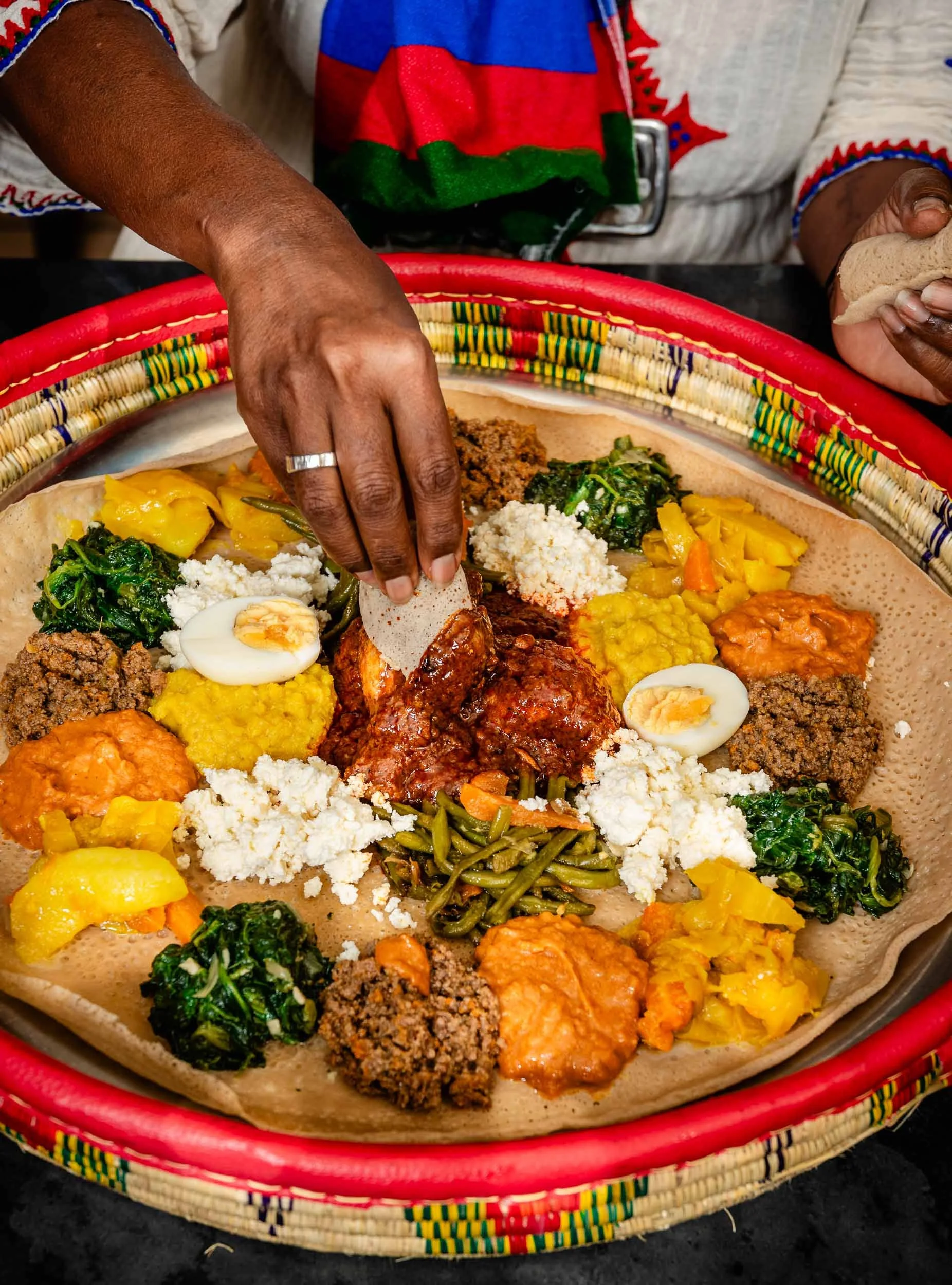Une éthiopienne est en train de piocher dans la nourriture au restaurant Messob à Lyon