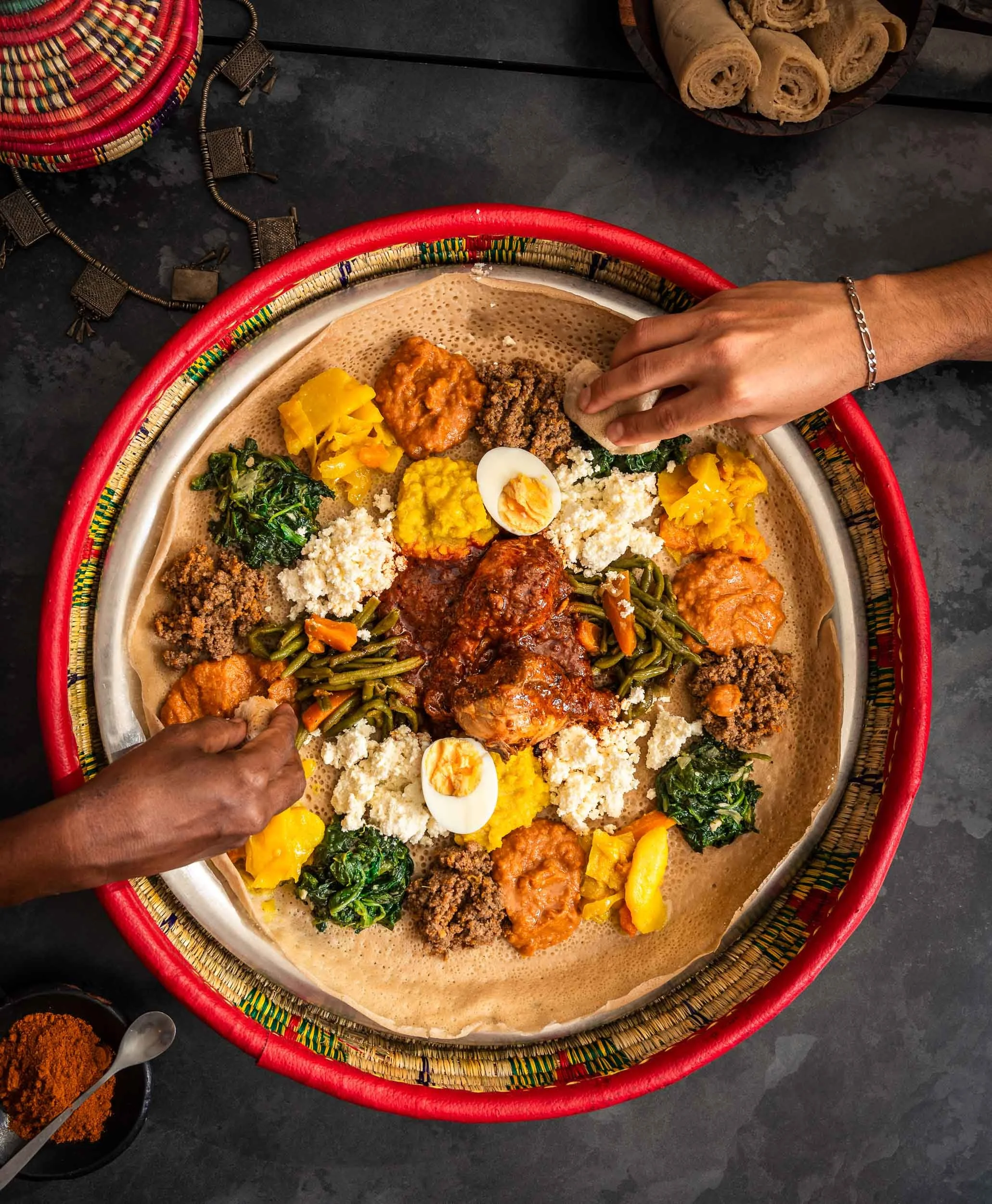 Plat éthiopien partagé par deux personnes qui mangent directement dans l'injara au restaurant éthiopien Messob à Lyon 6