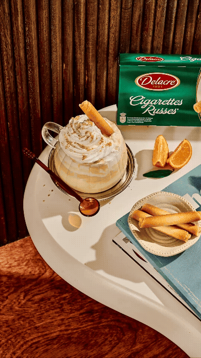 Crème glacée à la vanille avec un biscuit, accompagnée d'une boîte de cigarettes russes, d'une tranche d'orange, de cigarettes et d'une boîte de biscuits.