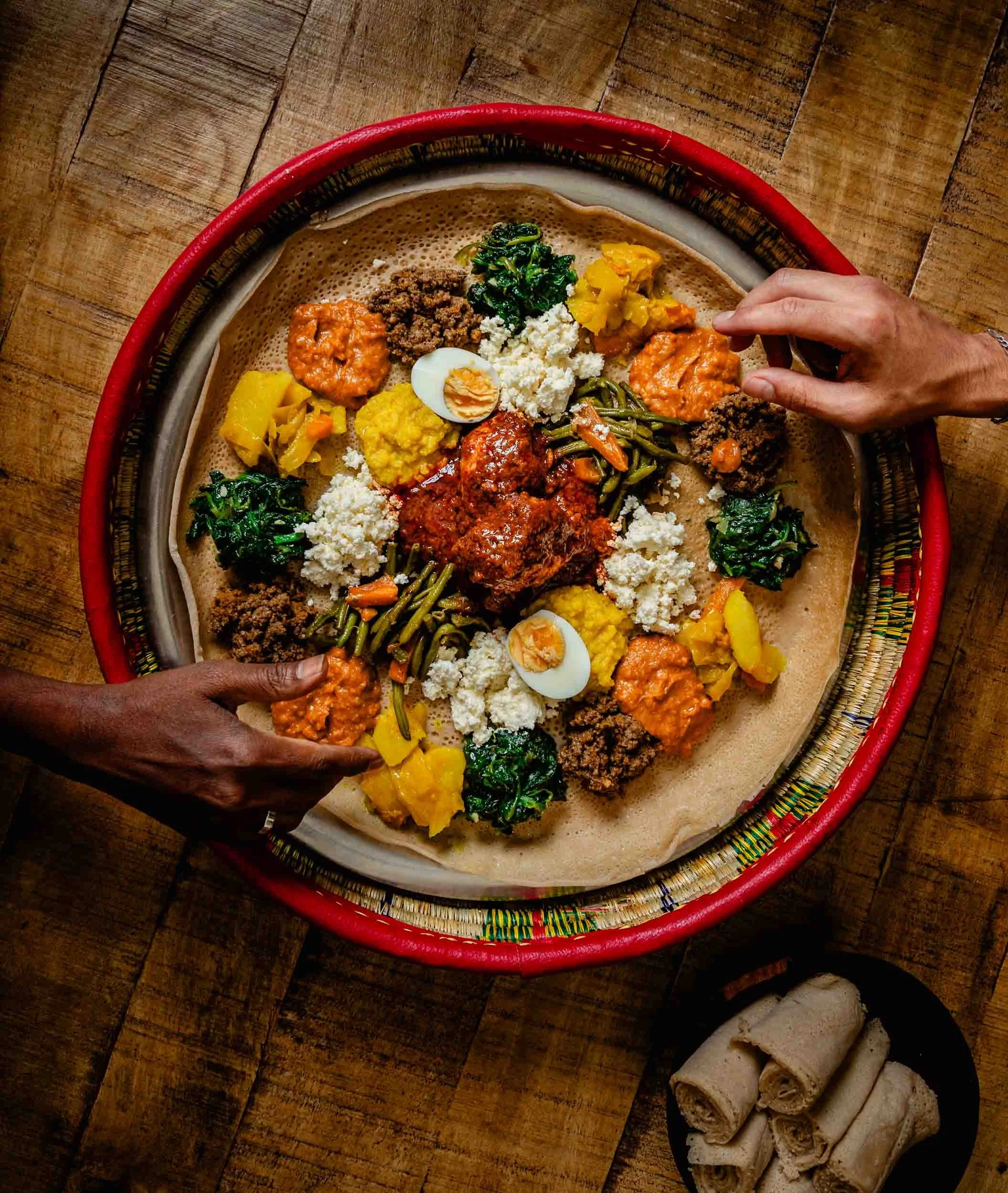 Photographie de deux clients qui consomment l'injara dans le restaurant éthiopien Messob