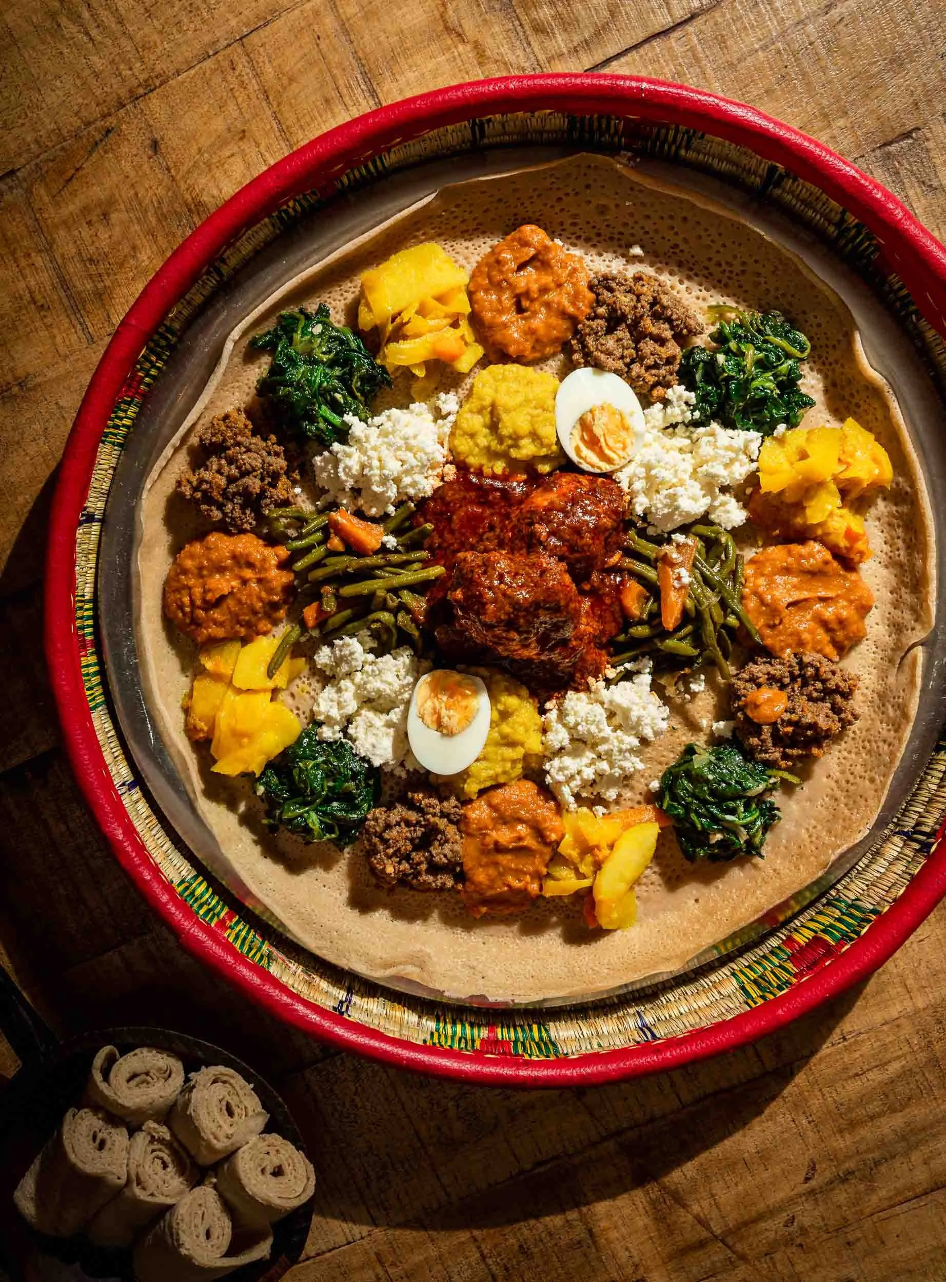 Photographie d'un plat éthiopien entier avec des garnitures dans le restaurant Messob à Lyon