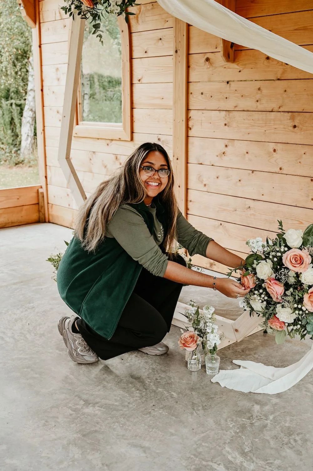 Hanifah setting up flowers on a ceremony backdrop.