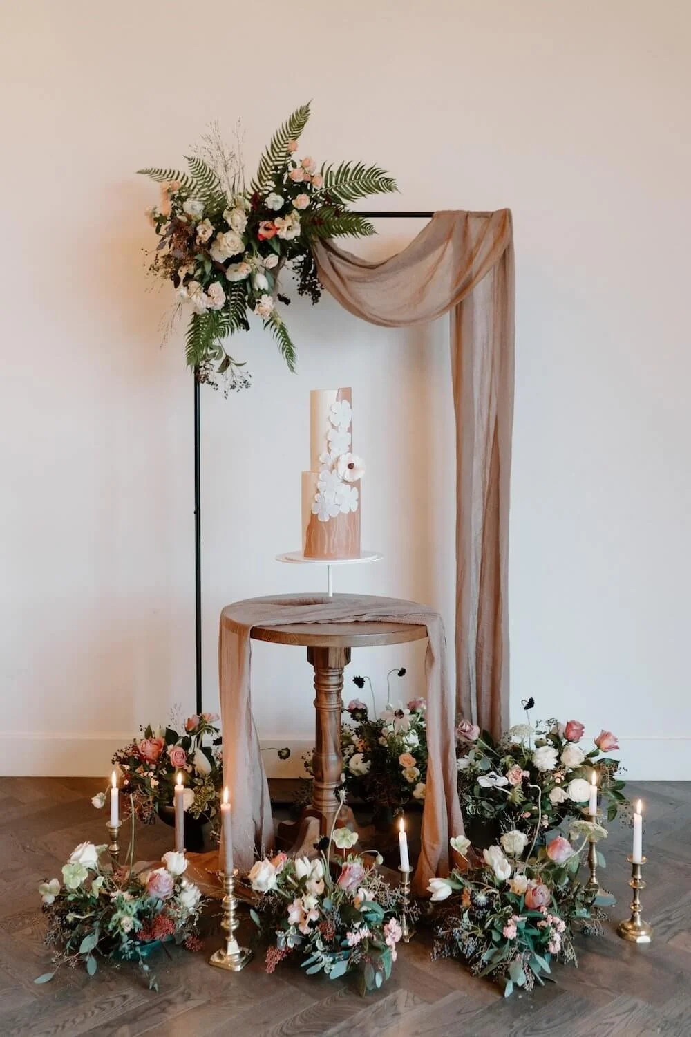 Cake Display at The Barnsdale. Cake surrounded by Flowers and Metal Frame.