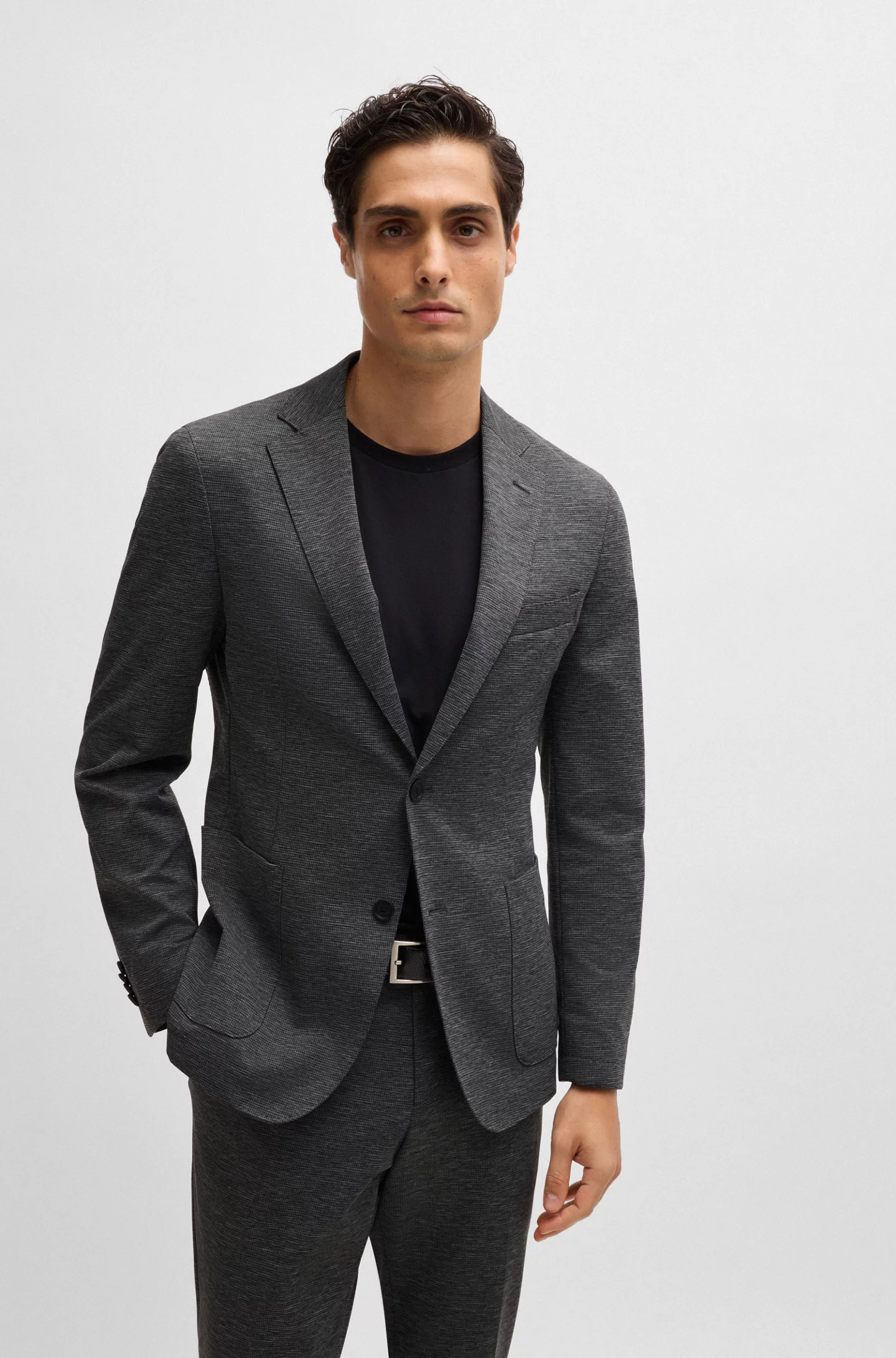 a male model wearing a charcoal jacket over a plain black t-shirt