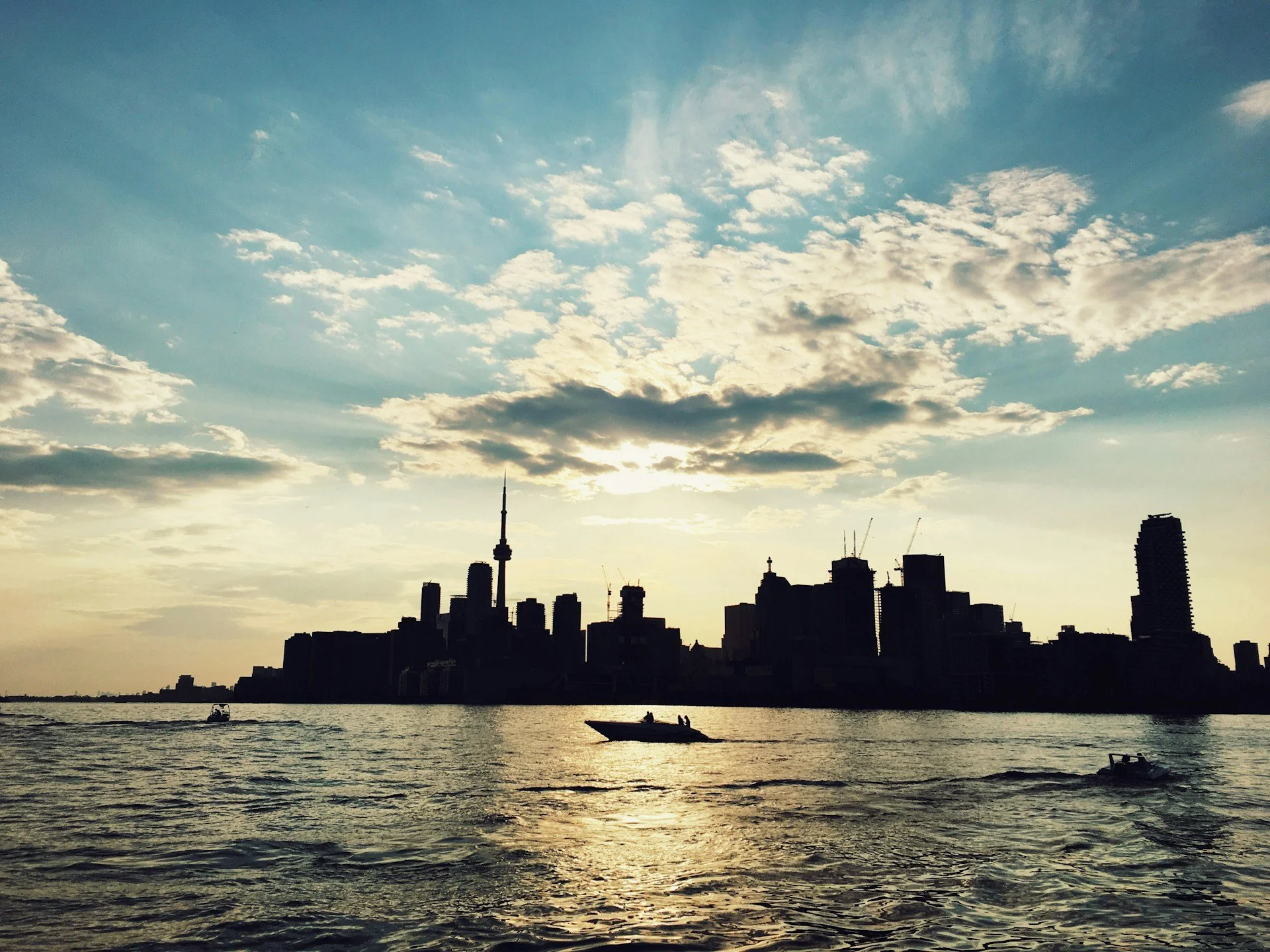 a silhouette of Toronto's horizon from the lakeshore, during summer