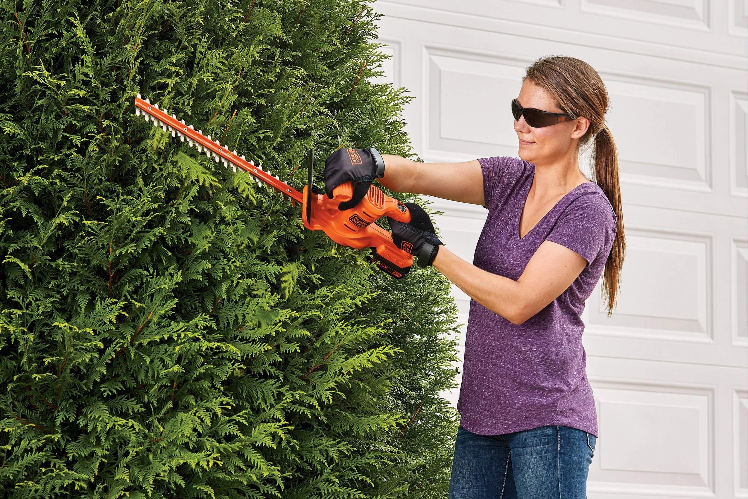 woman-using-hedgetrimmer-cutting-bushes.jpg