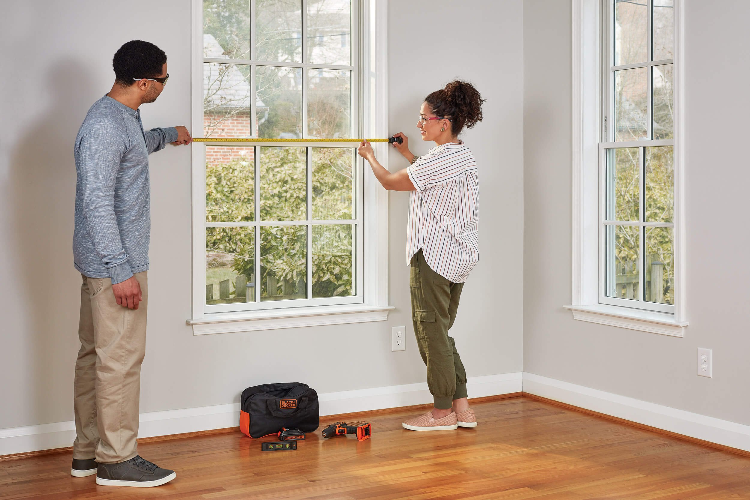 couple-measuring-hanging-curtains.jpg