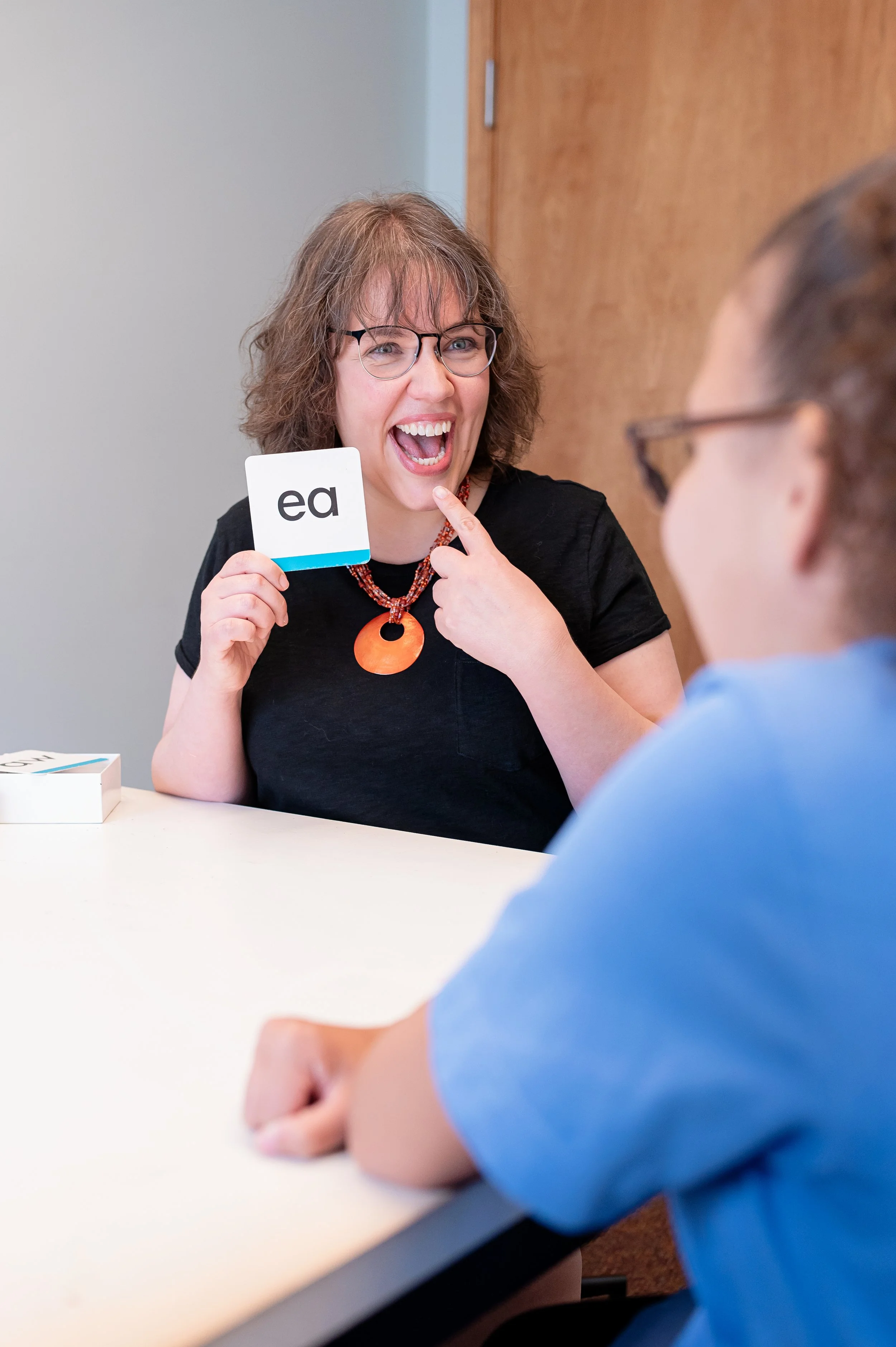 A professional using a letter card during a learning activity.