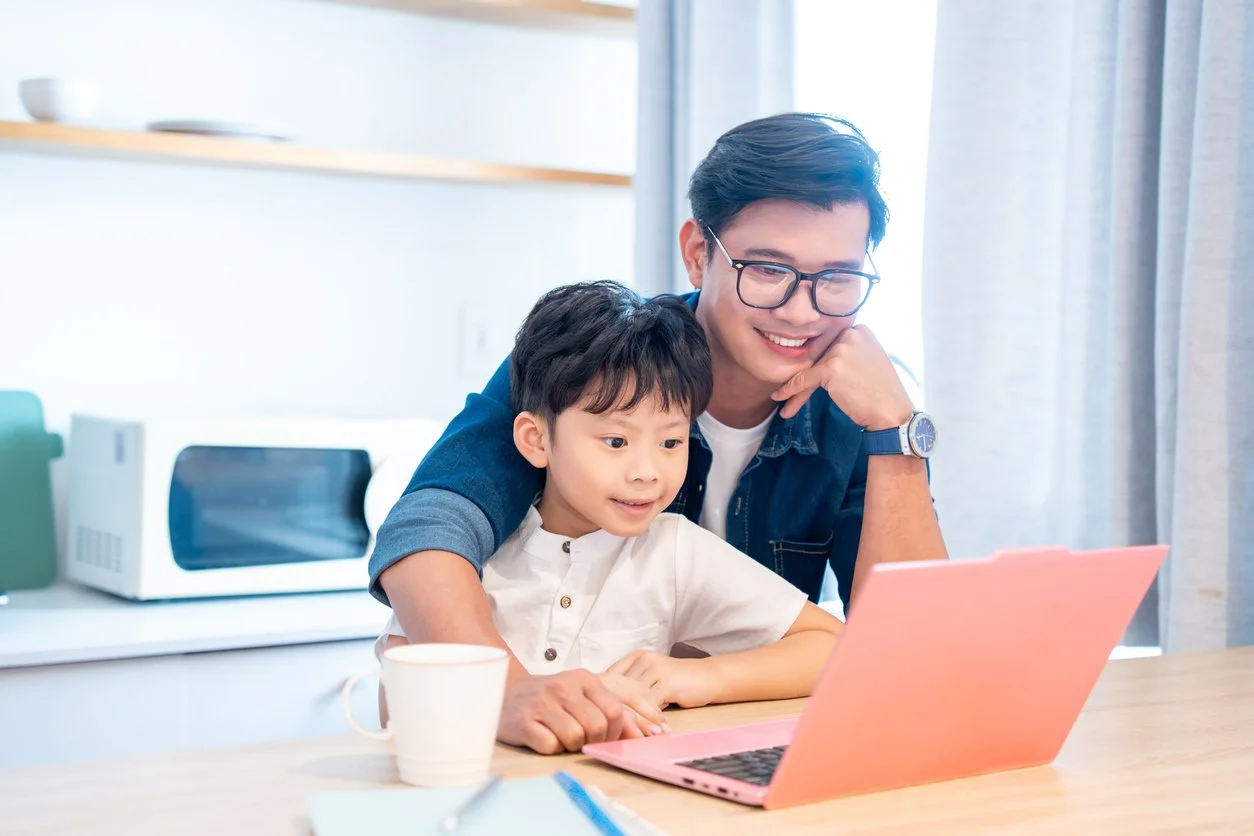 A parent and child exploring information on a laptop.