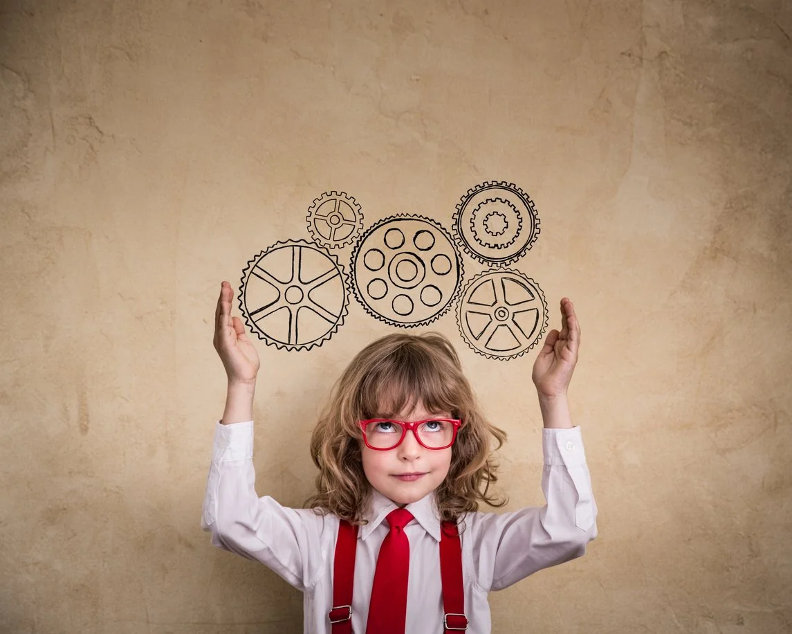 A child beneath an illustration of connected gears.