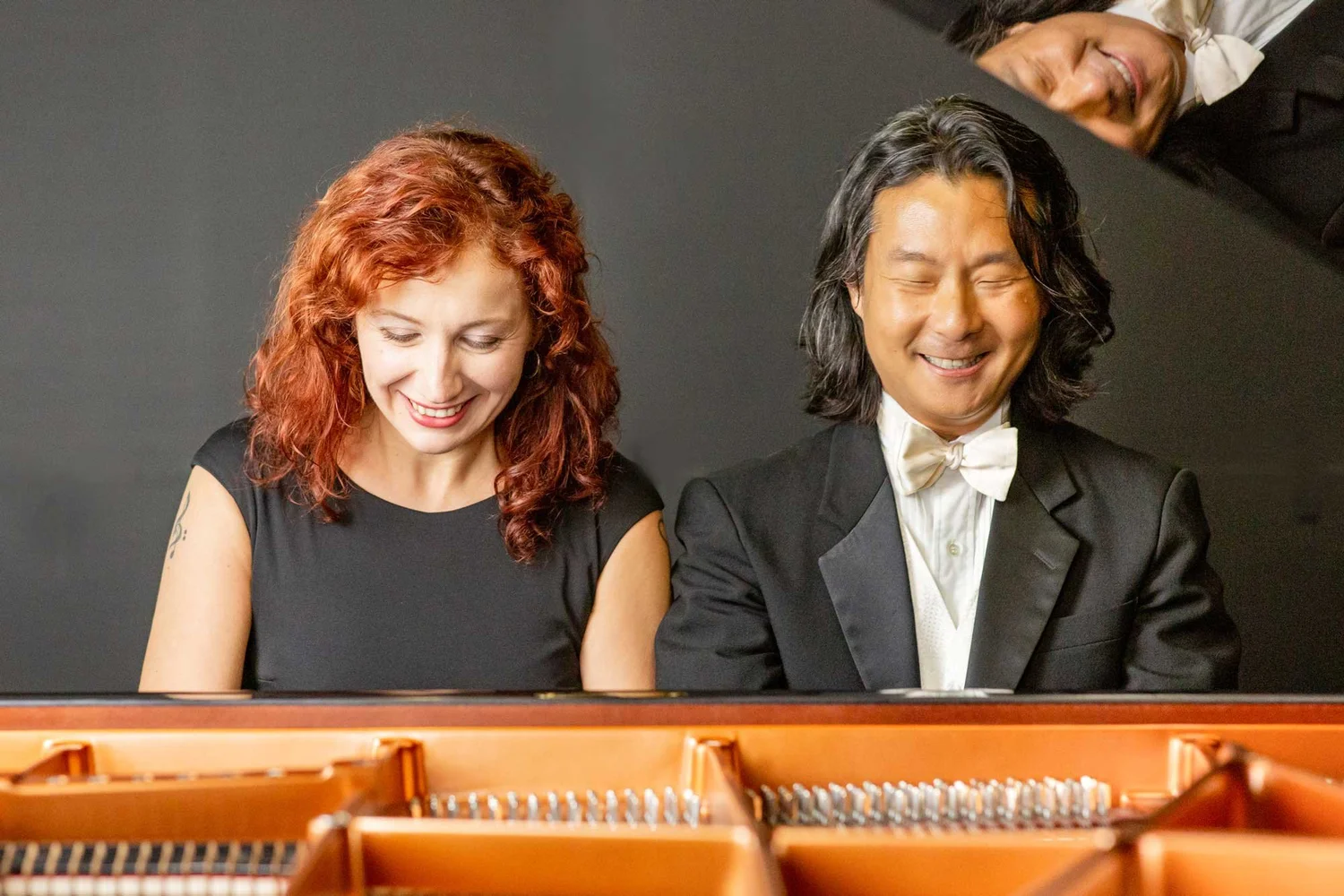 Mădălina Dănilă and Hugh Sung smiling at the piano