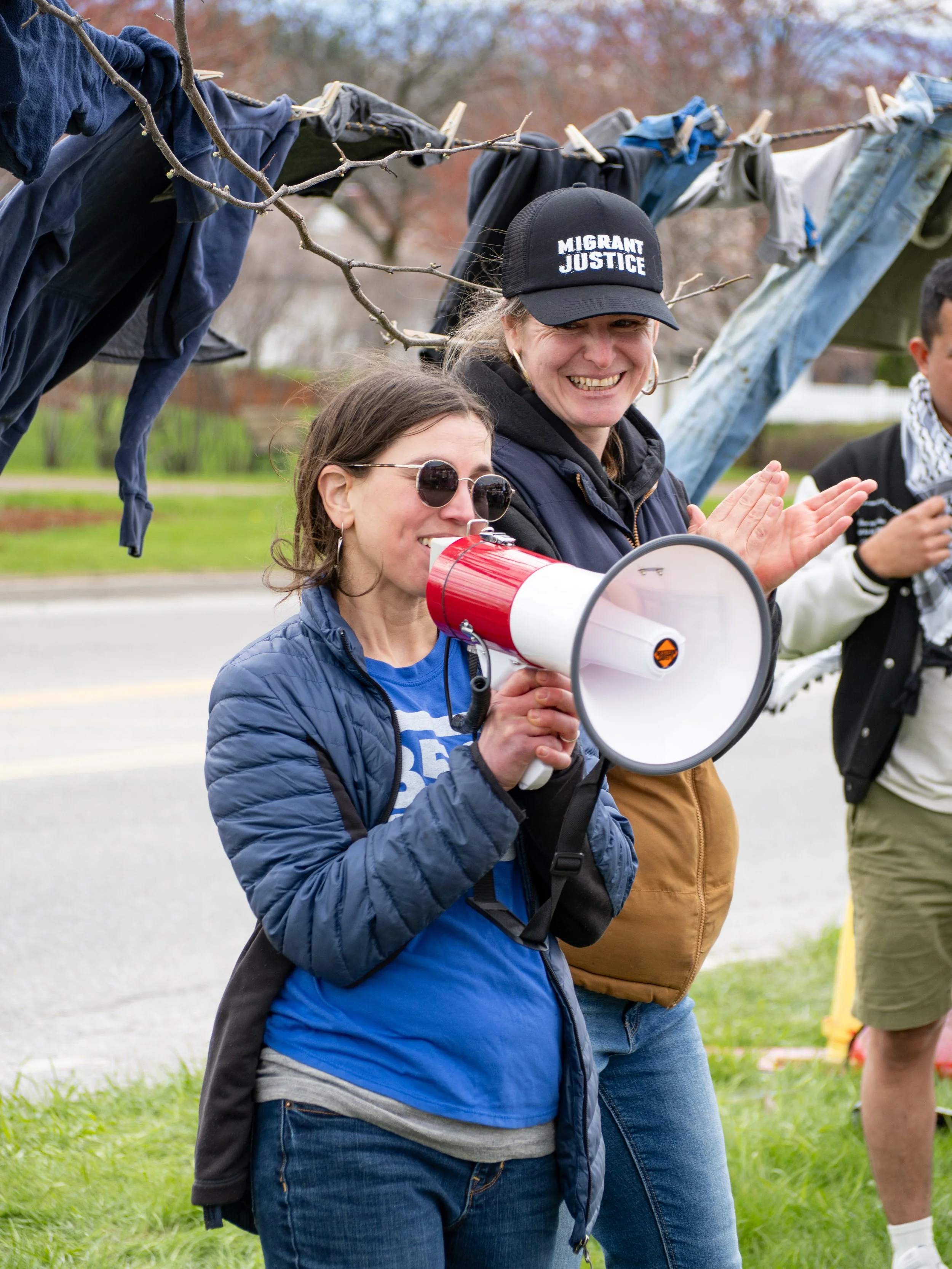  Representatives from 350VT and Migrant Justice speak at the picket with a megaphone. 