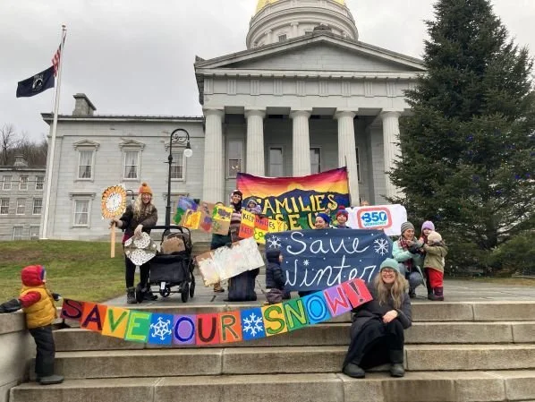 Folks from Families Rise Up with colorful signs on the statehouse lawn