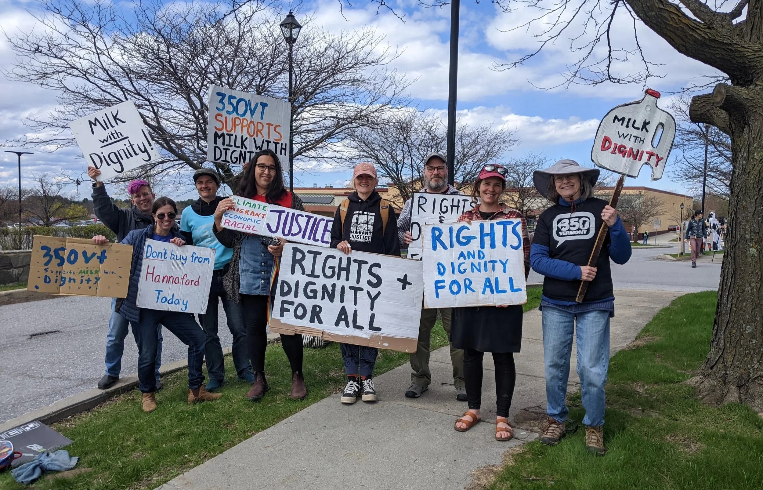 350VTers pose near the Williston Hannafords with signs saying "Milk with Dignity," "Rights & Dignity for All," and "Don't buy from Hannaford today."