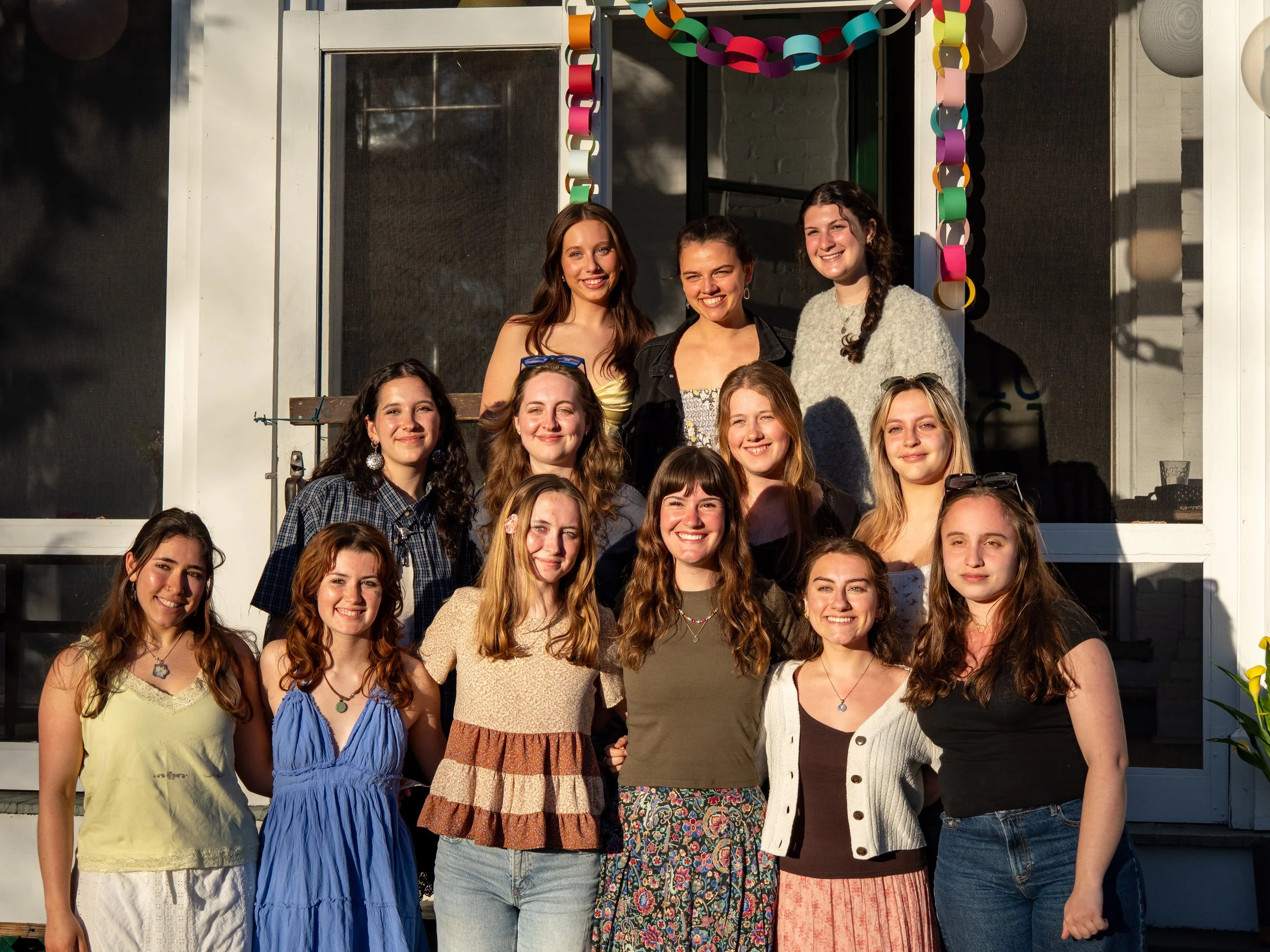 A group of CAC members smiling in front of a house.