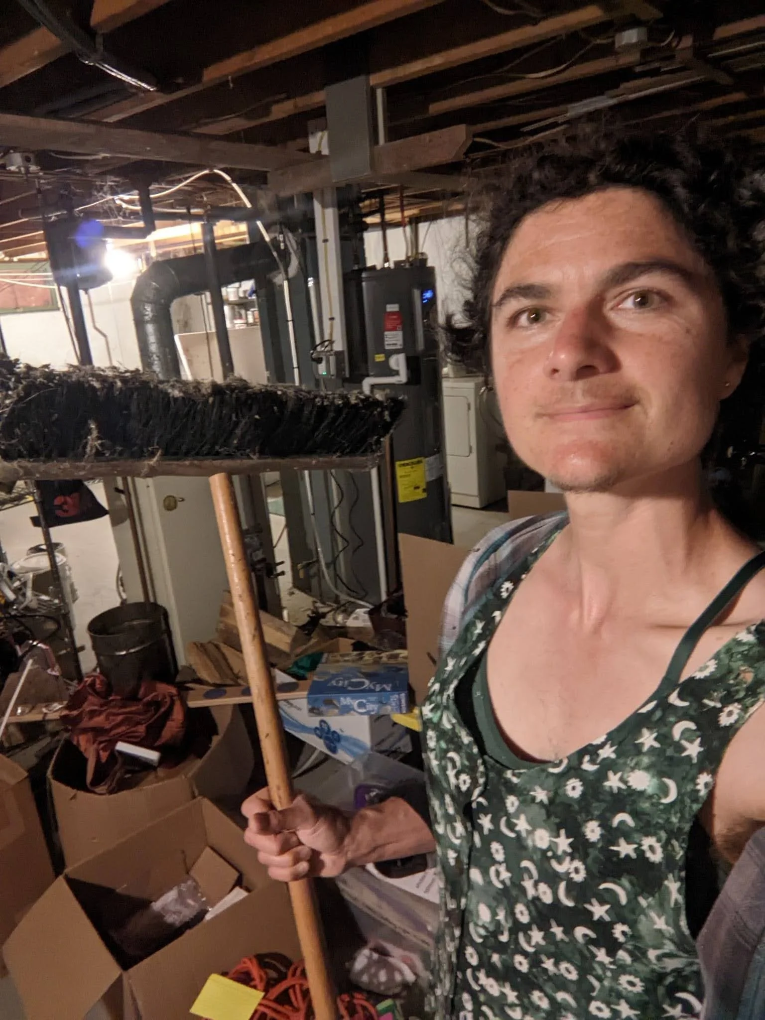 Volunteer Marisa in her basement holding a broom