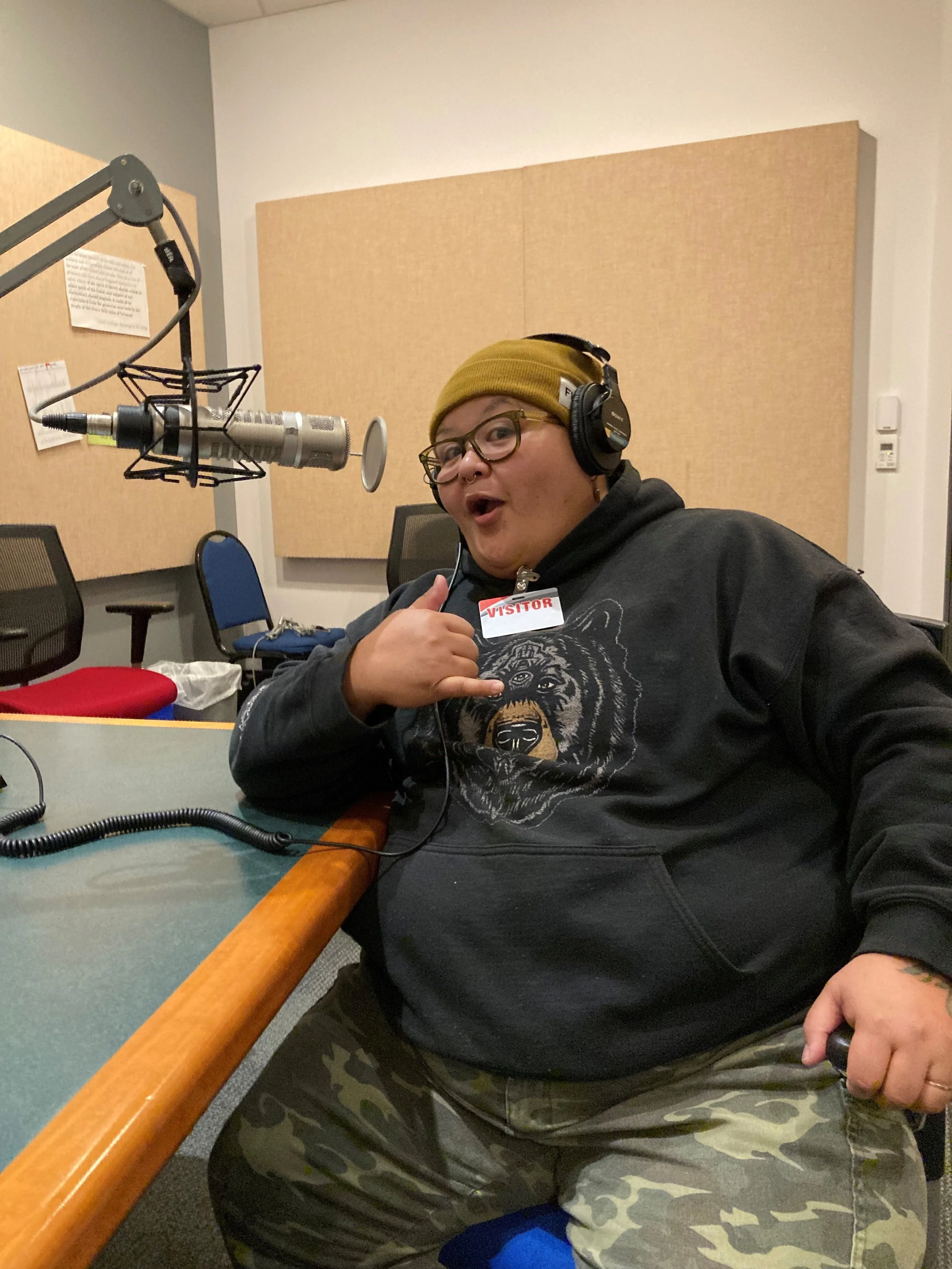 Ita wearing headphones and sitting in front of a microphone