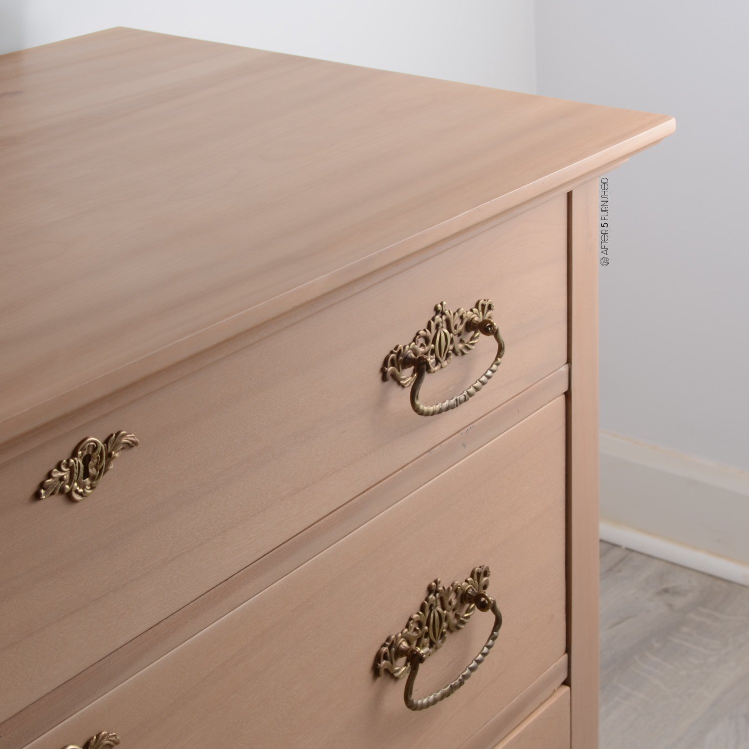 Close-up of solid brass drawer pulls on antique maple dresser