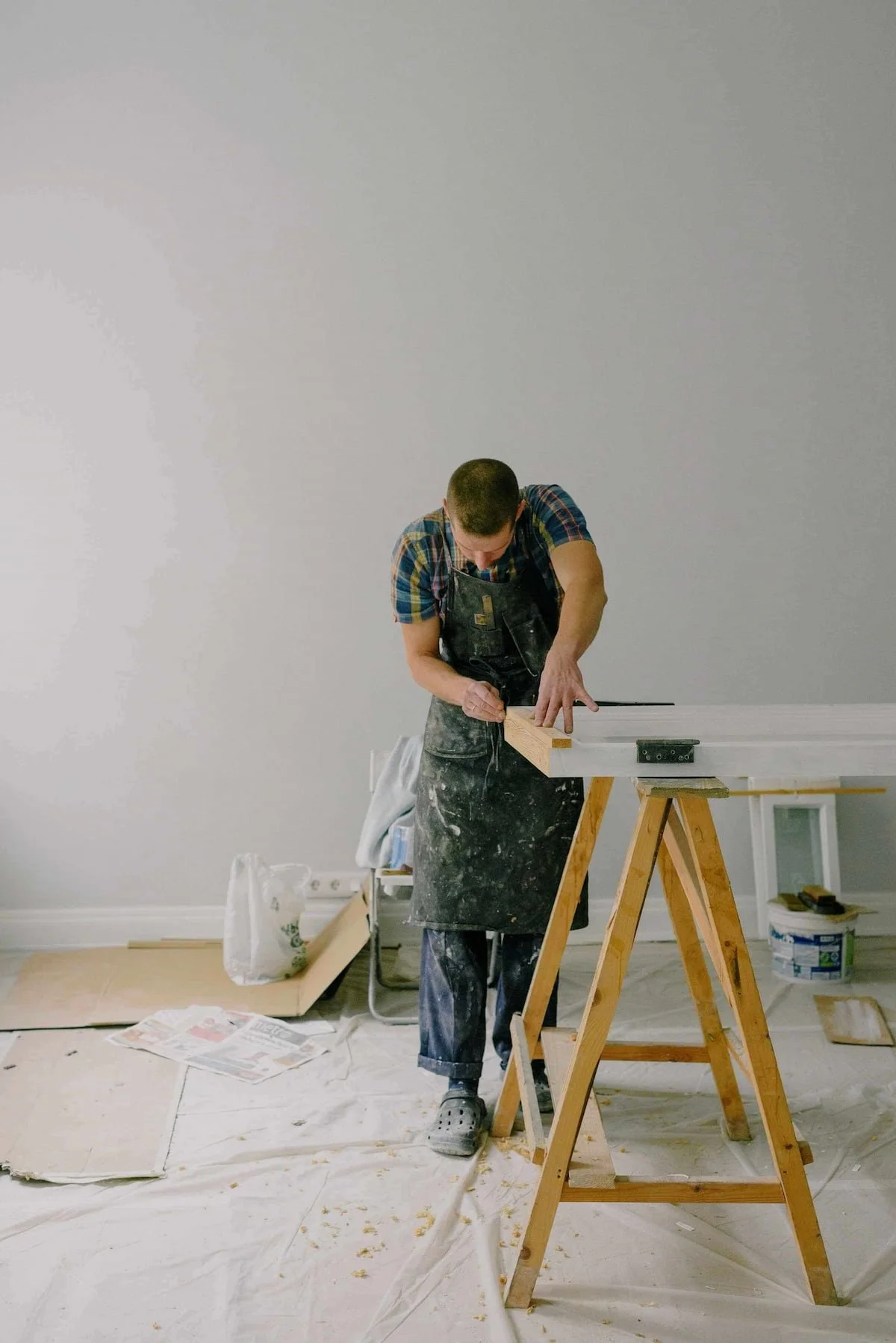 General contractor measuring a door in a white room.