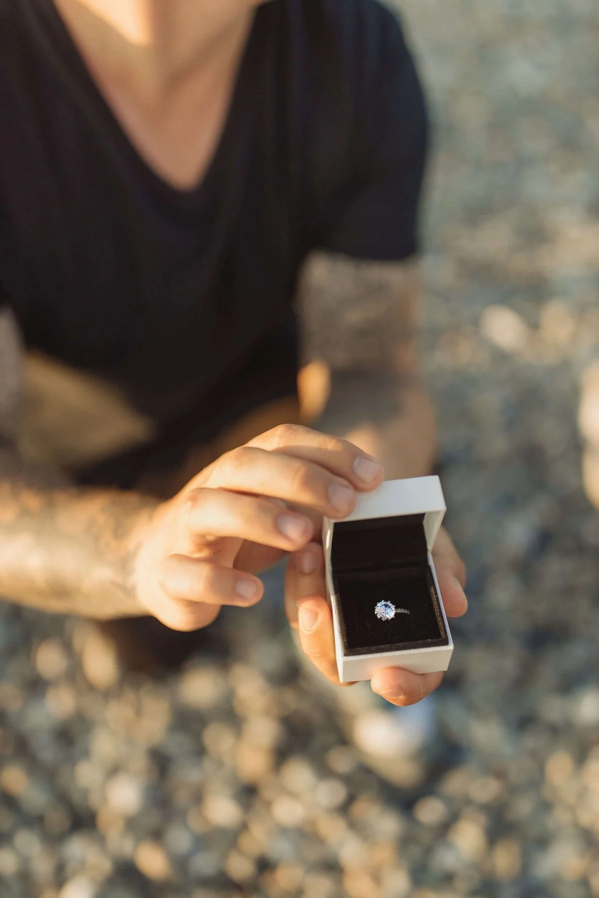 A man on one knee proposing with a ring.