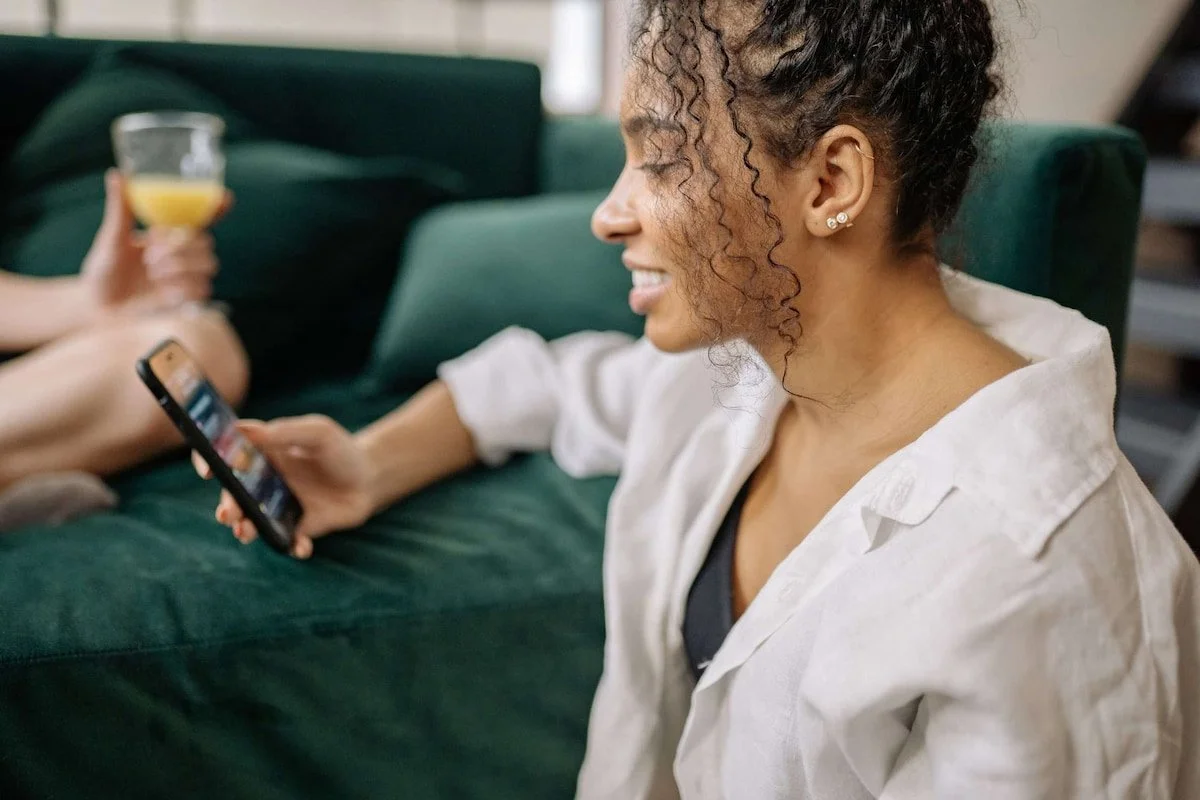 A lady looks to her phone to make a payment.