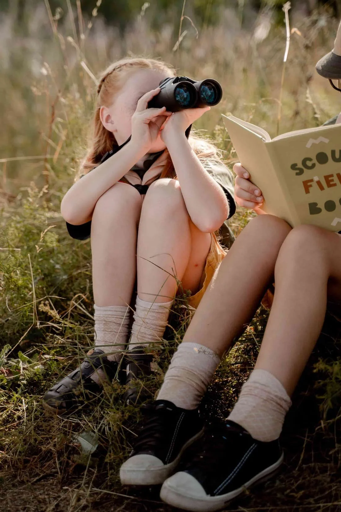 Girl dressed as a scout with binoculars