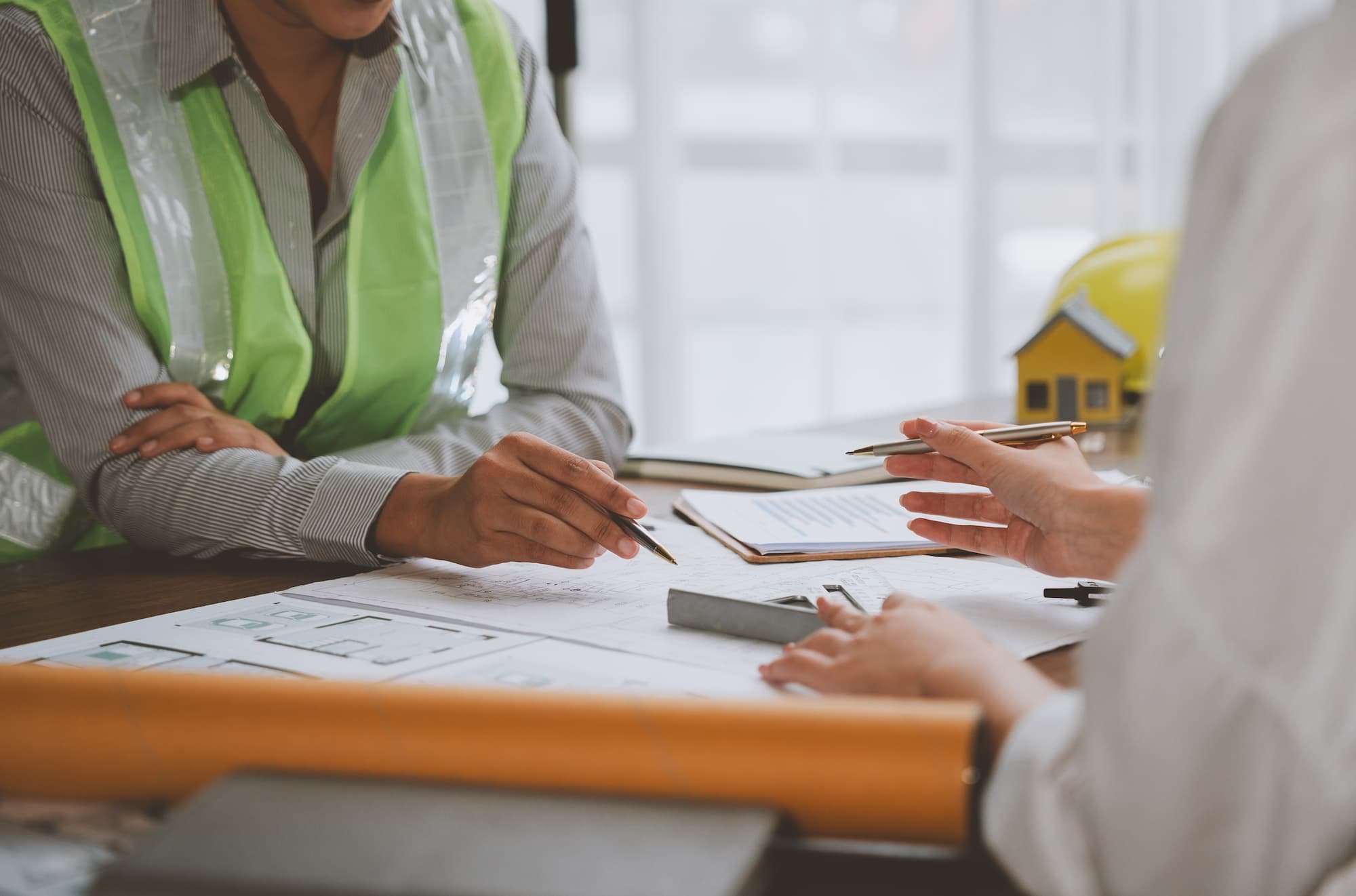 Construction workers analyzing blueprint and discussing a project.
