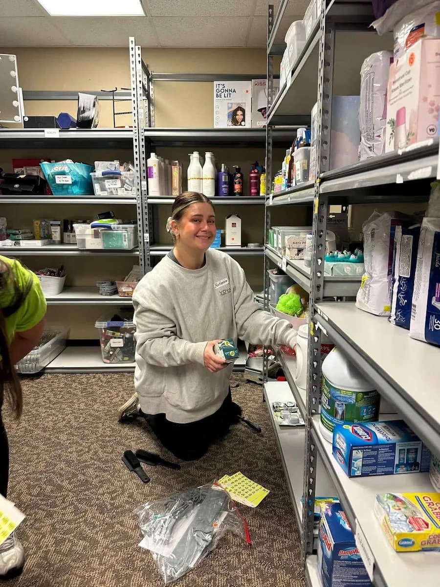 Voyage FCU team member MacKenzie stocking shelves for Volunteers of America Great Goods in Sioux Falls, SD in November of 2023