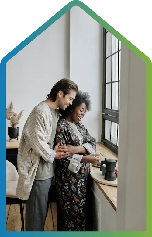 A couple holding each other in their home.