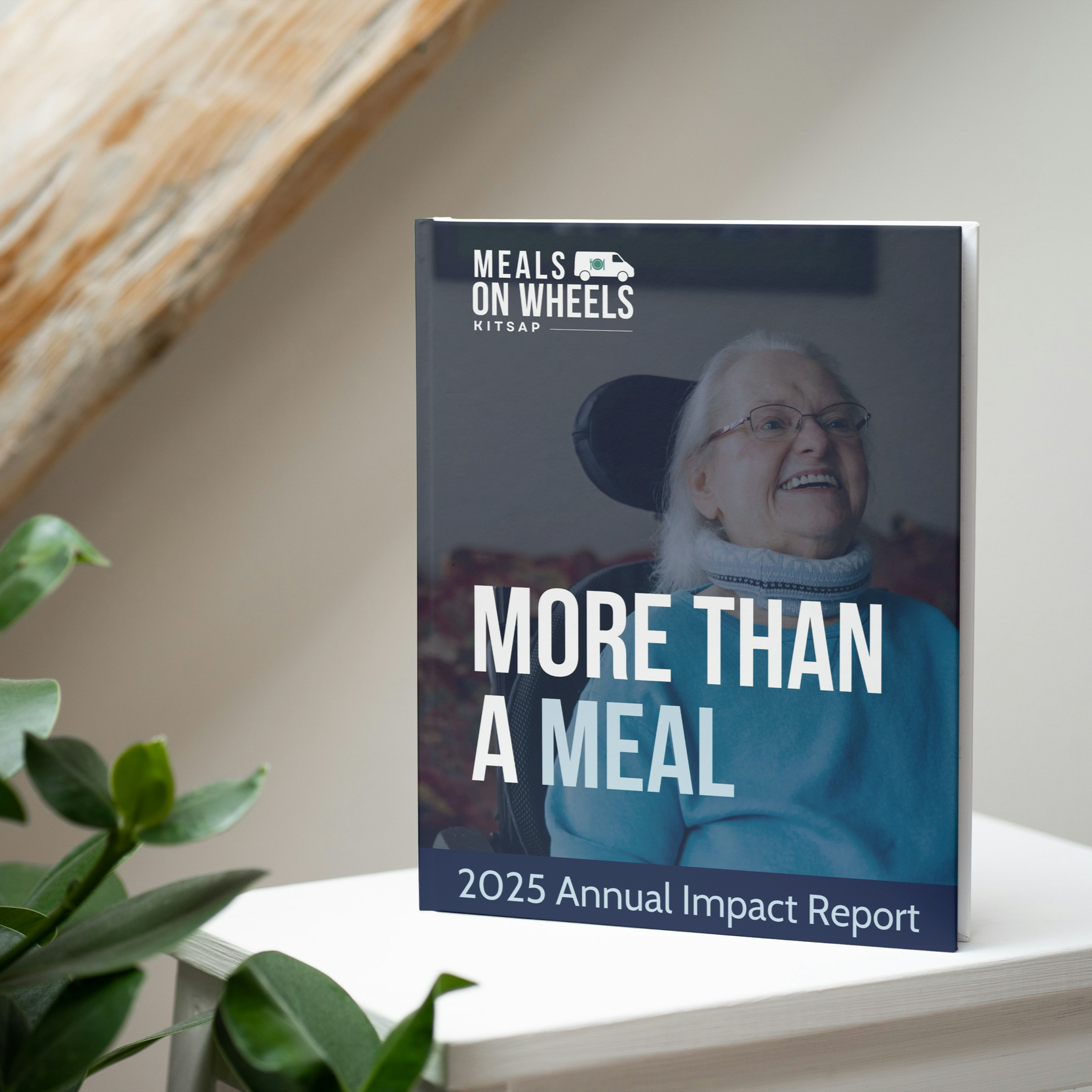 Cover of the 2025 Annual Impact Report for Meals on Wheels Kitsap, featuring a smiling elderly woman with glasses in a wheelchair.