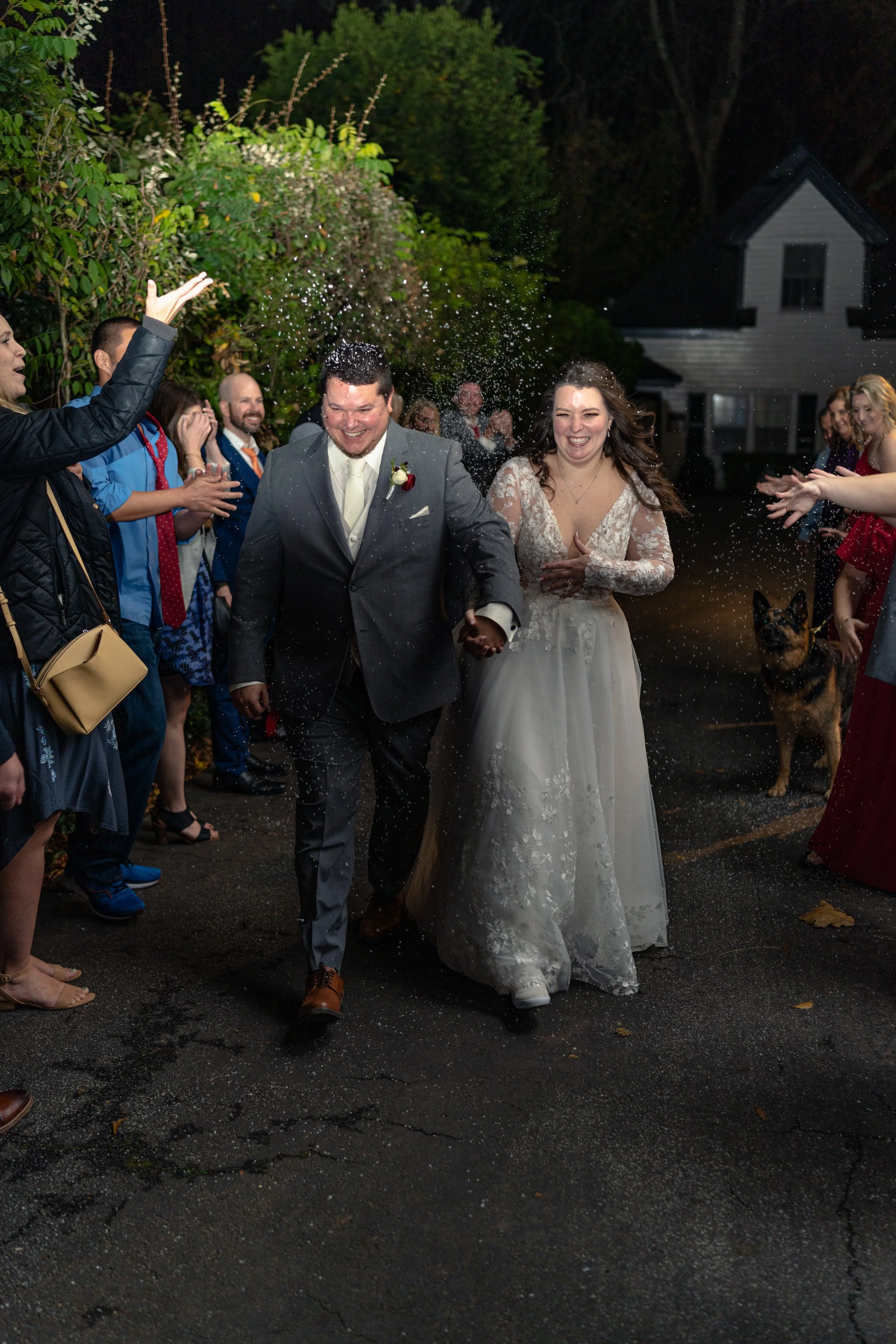 Bride and groom walking through a crowd of people celebrating.