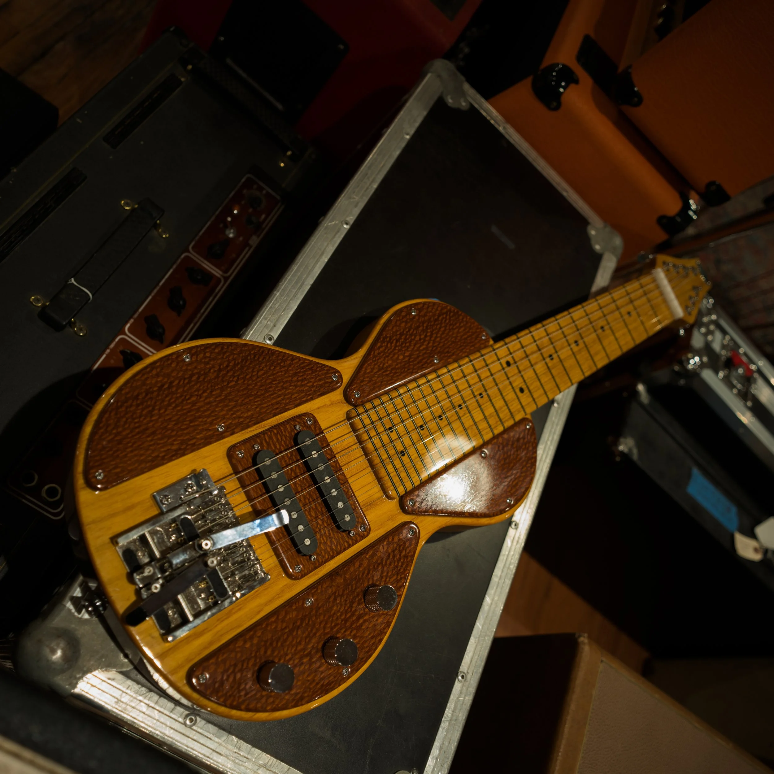Close-up of lap steel guitar laying on a travel case.