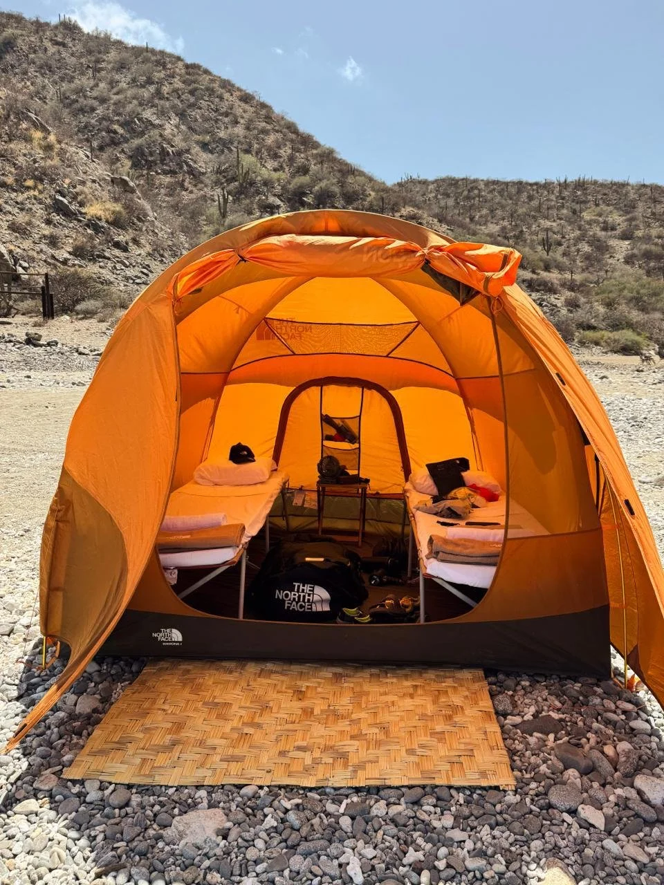 Tienda de campaña The North Face abierta con equipo de camping en desierto de Baja California Sur
