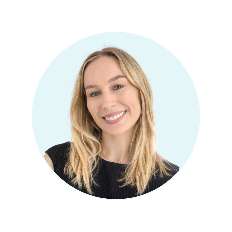 Lauren Reinsfield, a woman with medium blonde hair tied up and light skin, smiling in front of a light blue background.