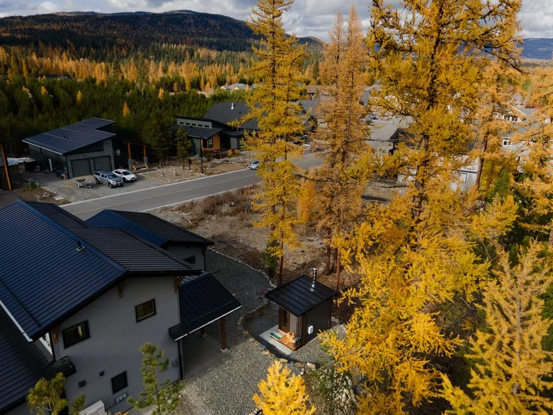 Aerial view of a Mettä backyard sauna among golden larches in the Kootenays