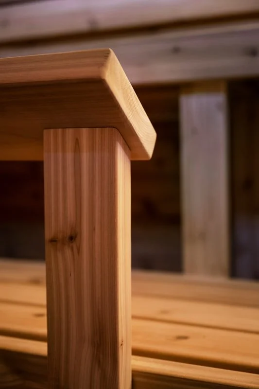 Close-up of a cedar sauna bench corner and leg, TMBR | Kamu sauna